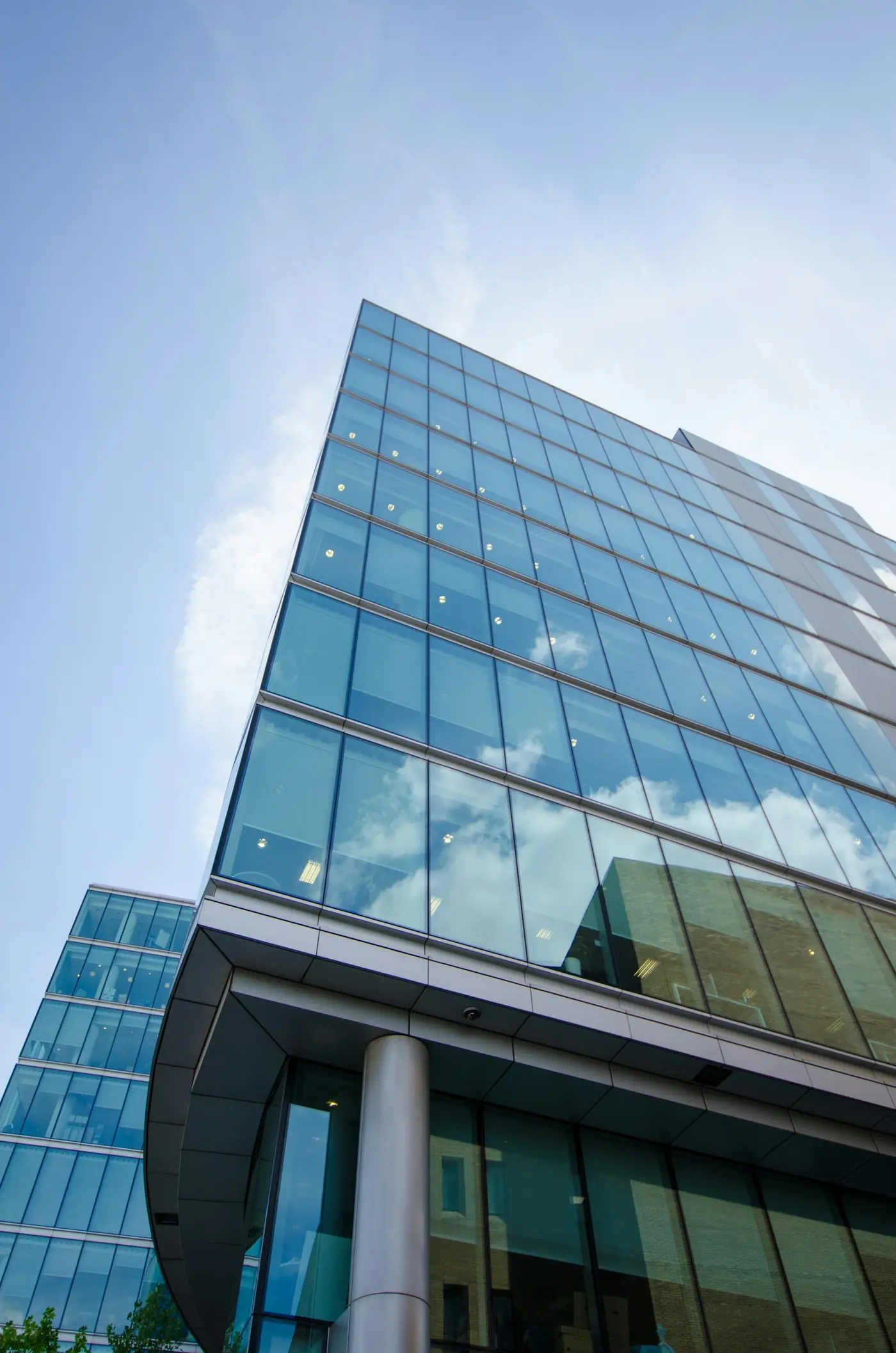 Glass facade of a modern commercial office building against a blue sky